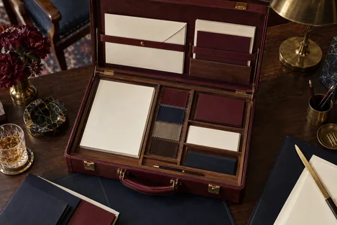 An open burgundy sample case holds cream stationery and fabric color swatches.